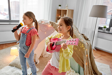 Image showing girls with guitar and microphone playing at home