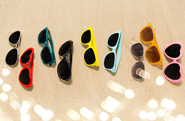 Image showing different sunglasses on beach sand