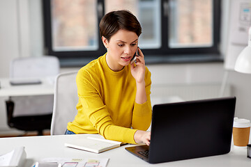 Image showing businesswoman with laptop calling on smartphone