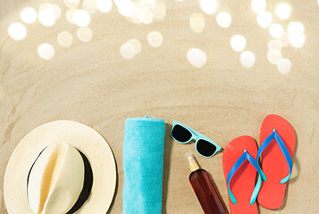 Image showing straw hat, flip flops and sunglasses on beach sand