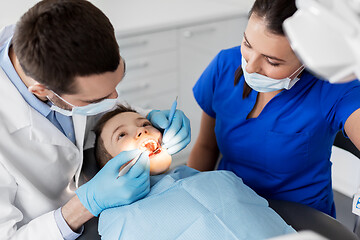 Image showing dentist checking for kid teeth at dental clinic