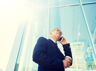 Image showing senior businessman calling on smartphone in city