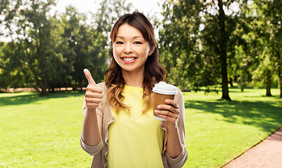 Image showing asian woman drinking coffee and showing thumbs up