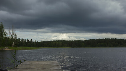 Image showing Dark Overcast Sky With Thunderclouds Over The Forest Lake