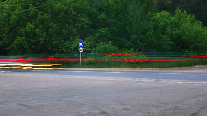 Image showing Blurred Glowing Lines of Headlights and Traffic Sign on the Coun