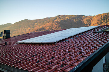 Image showing Tile roof with solar panel on a mountain background, Austria.