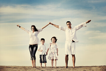 Image showing family on beach showing home sign