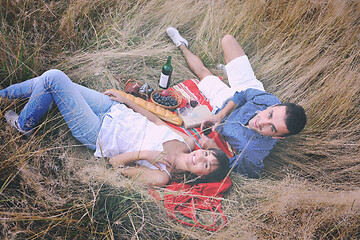 Image showing happy couple enjoying countryside picnic in long grass