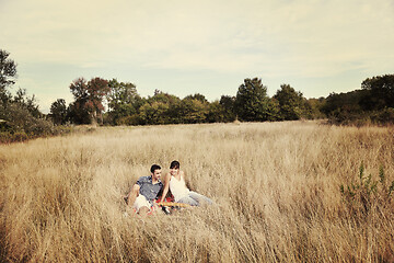 Image showing happy couple enjoying countryside picnic in long grass