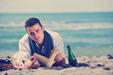 Image showing man reading book at beach