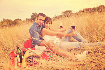 Image showing happy couple enjoying countryside picnic in long grass