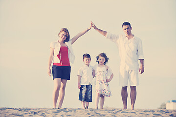 Image showing family on beach showing home sign