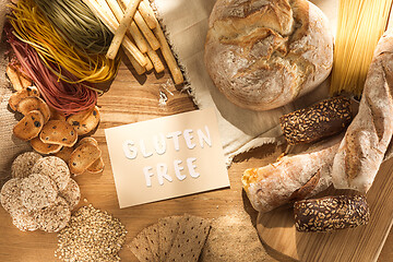 Image showing Gluten free food. Various pasta, bread and snacks on wooden background from top view