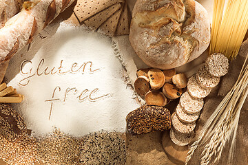 Image showing Gluten free food. Various pasta, bread and snacks on wooden background from top view