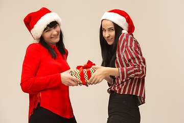 Image showing Happy family in Christmas sweater posing on a red background in the studio.