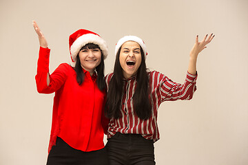 Image showing Happy family in Christmas sweater posing on a red background in the studio.