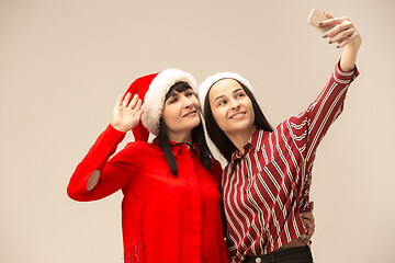 Image showing Happy family in Christmas sweater posing on a red background in the studio.