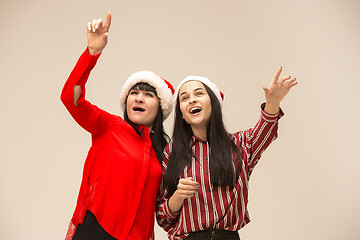 Image showing Happy family in Christmas sweater posing on a red background in the studio.