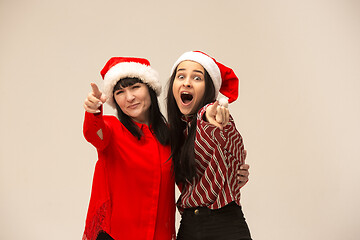 Image showing Happy family in Christmas sweater posing on a red background in the studio.