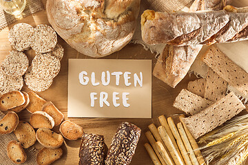 Image showing Gluten free food. Various pasta, bread and snacks on wooden background from top view