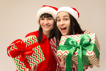 Image showing Happy family in Christmas sweater posing on a red background in the studio.