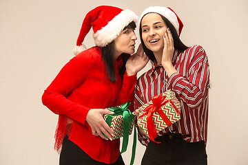 Image showing Happy family in Christmas sweater posing on a red background in the studio.