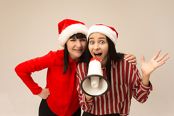 Image showing Happy family in Christmas sweater posing on a red background in the studio.