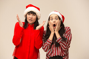 Image showing Happy family in Christmas sweater posing on a red background in the studio.