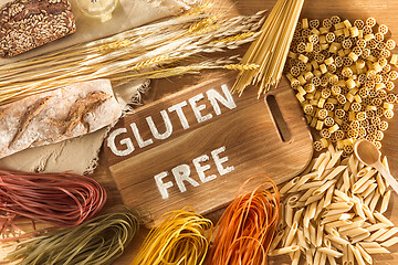 Image showing Gluten free food. Various pasta, bread and snacks on wooden background from top view