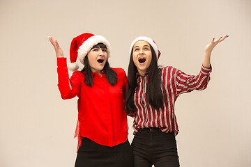 Image showing Happy family in Christmas sweater posing on a red background in the studio.