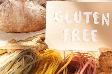 Image showing Gluten free food. Various pasta, bread and snacks on wooden background from top view