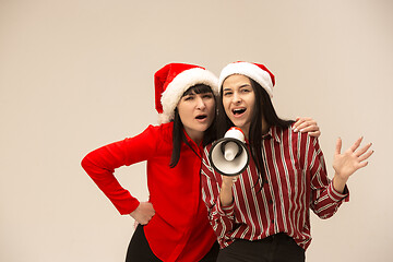 Image showing Happy family in Christmas sweater posing on a red background in the studio.