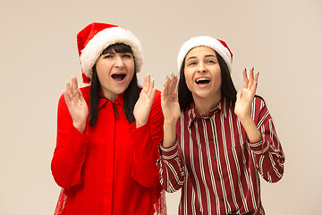 Image showing Happy family in Christmas sweater posing on a red background in the studio.