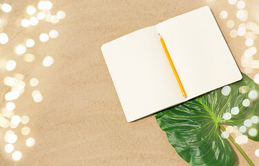 Image showing notebook with pencil and leaf on beach sand