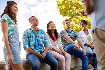 Image showing happy international friends talking in city