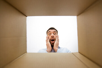 Image showing shocked man looking into open parcel box