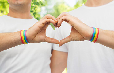 Image showing gay couple with rainbow wristbands and hand heart