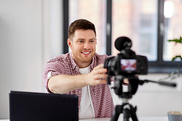 Image showing male video blogger adjusting camera at home office