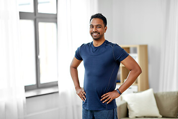 Image showing smiling indian man with fitness tracker at home