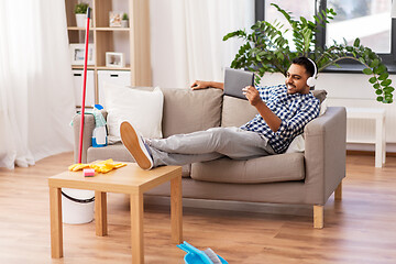 Image showing indian man in headphones after cleaning home