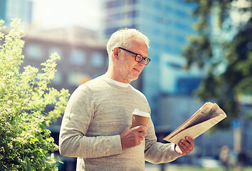 Image showing senior man reading newspaper and drinking coffee