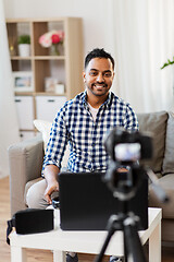 Image showing male blogger with camera videoblogging at home