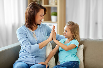 Image showing mother and daughter making high five at home