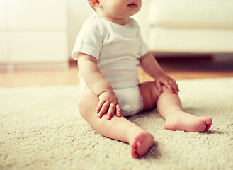 Image showing happy baby boy or girl sitting on floor at home