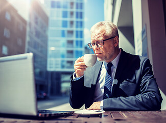 Image showing senior businessman with laptop drinking coffee