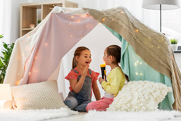 Image showing girls playing with torch in kids tent at home