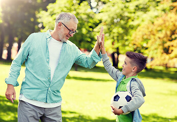 Image showing old man and boy with soccer ball making high five