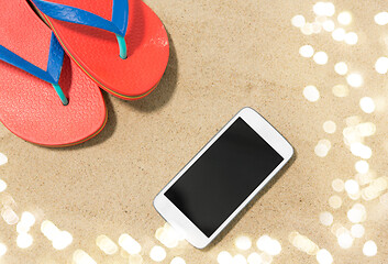 Image showing smartphone and flip flops on beach sand