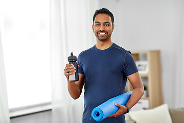 Image showing indian man with exercise mat and bottle at home