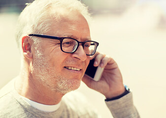 Image showing happy senior man calling on smartphone in city